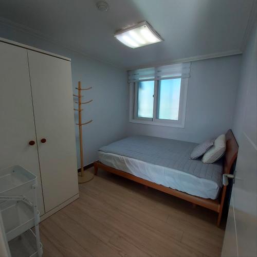 ein kleines Schlafzimmer mit einem Bett und einem Fenster in der Unterkunft Green Homestay - Foreigner Only in Seoul