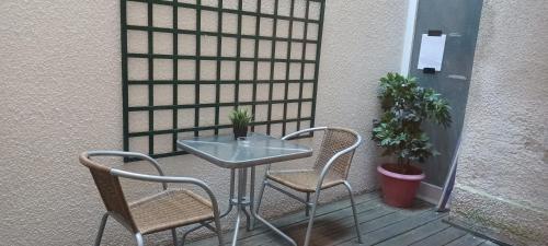 une table en verre et deux chaises sur la terrasse dans l'établissement Studio Hypercentre Tourny, à Bordeaux