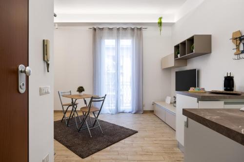 uma cozinha e sala de jantar com mesa e cadeiras em Sister's Suites Rooms em Palermo