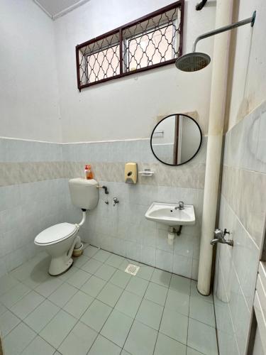 La salle de bains est pourvue de toilettes et d'un lavabo. dans l'établissement Te’bing Homestay, à Paka