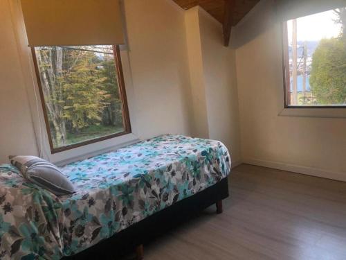 um quarto com uma cama e duas janelas em Dream Landscape em Ushuaia