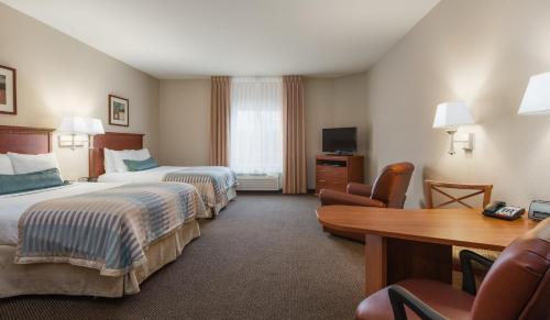 a hotel room with two beds and a desk at Candlewood Suites Houston I-10 East, an IHG Hotel in Houston