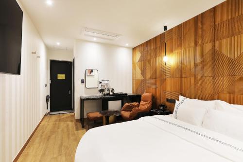 忠州市にあるMari Hotelのベッドとデスクが備わるホテルルームです。