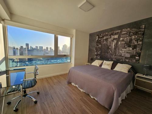 sypialnia z łóżkiem, biurkiem i oknem w obiekcie Puerto Madero frente al Hotel Hilton Vista a la Ciudad w BuenosAires