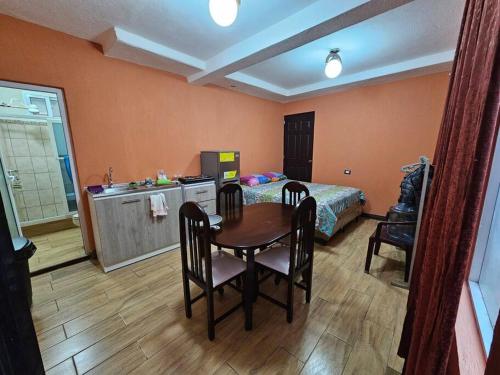 um quarto com uma mesa, uma cama e uma cozinha em Apartamento acogedor em Quetzaltenango