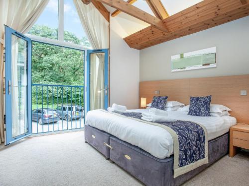 a bedroom with a large bed and a large window at Haven -80 in Perranwell