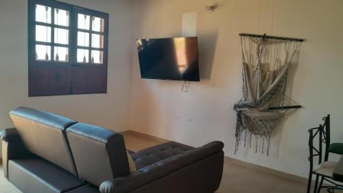 sala de estar con sofá y TV en hermosa casa en curití, en Curití