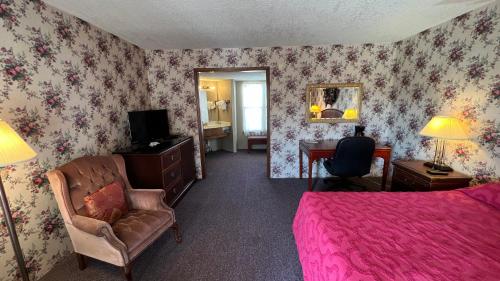 een slaapkamer met een bed, een stoel en een spiegel bij Victorian Inn in Cleveland