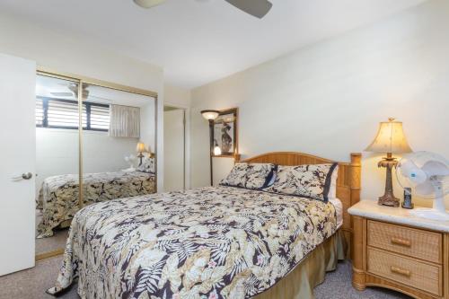 a bedroom with a bed and a dresser and a mirror at Kihei Surfside 613 - MCH in Kihei
