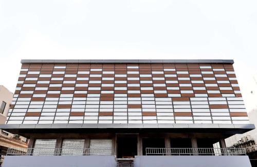 a tall building with a lot of windows at Hotel O Zion Inn in Vapi