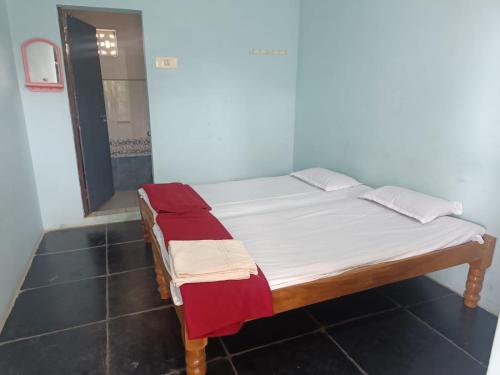 Best Home stay Hampi Anegundi في هامبي: سرير صغير في غرفة مع مرآة