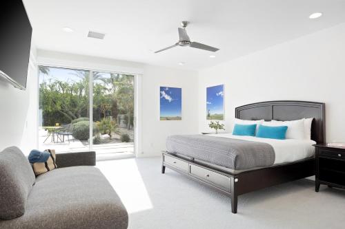 a bedroom with a bed and a couch and a window at Polo Villa 10 by AvantStay Backyard Oasis w Putting Green 260-320 6 Bedrooms in La Quinta