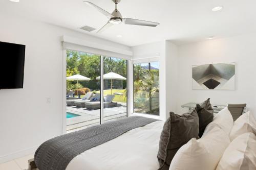 sypialnia z łóżkiem i telewizorem oraz patio w obiekcie Polo Villa 8 by AvantStay Kitchen, Pool & Spa 260-326 6 Bedrooms w mieście La Quinta