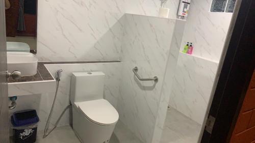 a white bathroom with a toilet and a sink at Saen Kam Resort in Chiang Mai