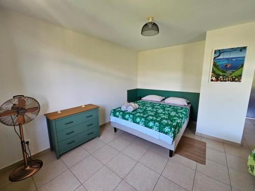 a bedroom with a green bed and a dresser at Studio Papeete City Center in Papeete