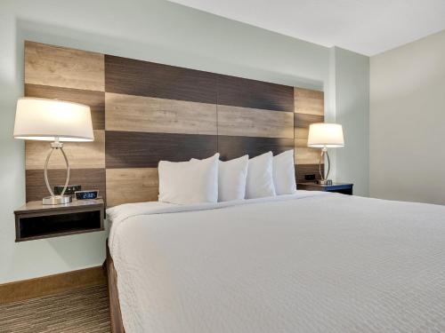 a hotel room with a large bed with two lamps at Country Inn & Suites by Radisson Rehoboth Beach - Dewey in Rehoboth Beach