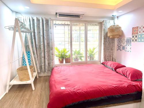 a red bed in a room with a window at Duplex WARM HANOI, 2 bedrooms, Old Quarter, 3mins to Hoan Kiem Lake in Hanoi