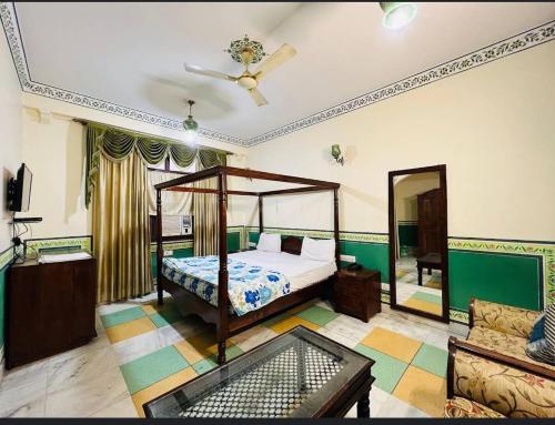 a bedroom with a bed and a ceiling fan at Rani Mahal Hotel in Jaipur