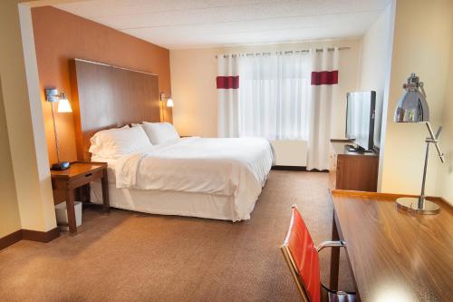 コロンバスにあるFour Points by Sheraton Columbus-Polarisのベッドとテレビが備わるホテルルームです。