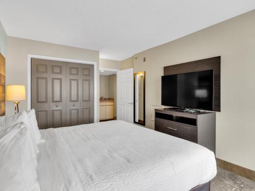 a bedroom with a large bed and a flat screen tv at Country Inn & Suites by Radisson Rehoboth Beach - Dewey in Rehoboth Beach