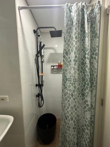 a shower with a shower curtain in a bathroom at City Nest Makati with Rooftop pool and Free Netflix in Manila