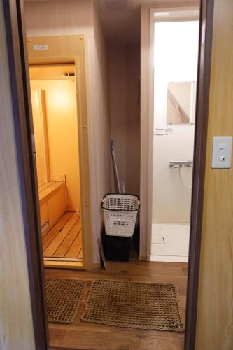 a bathroom with a door leading to a bathroom with a shower at とんかつ&ヒーリングハウスえん in Shimmachi