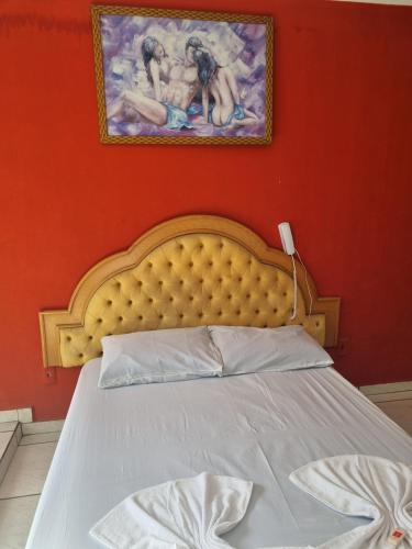 1 dormitorio con 1 cama con una pintura en la pared en Pousada Lances De Amor en Sorocaba