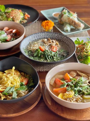 ein Tisch mit Suppenschüsseln und Tellern mit Essen in der Unterkunft Santera Village in Canggu
