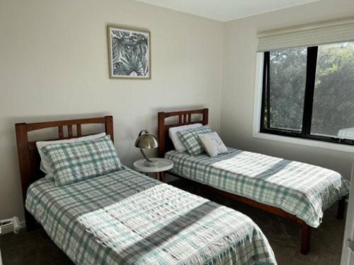Un dormitorio con dos camas y una ventana. en Spacious modern Gem Cozy Haven Lake & Beach oasis., en Lock Sport