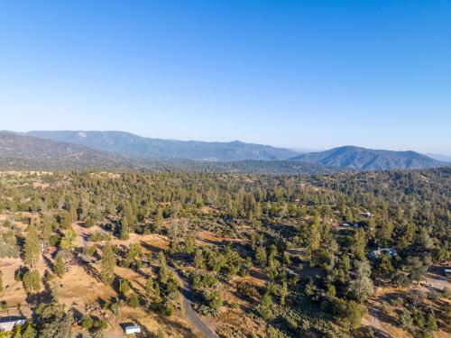 an aerial view of a forest with mountains in the background at Manzanita Rest in Mariposa