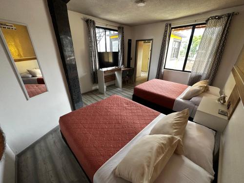 a hotel room with two beds and a mirror at CASA MARIN Pochote in Oaxaca City