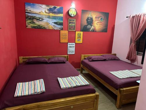 two beds in a room with red walls at Chidambaram Spiritual Stay in Chidambaram