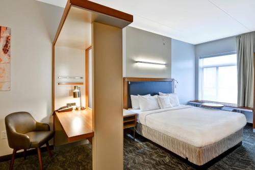a hotel room with a bed and a desk and a chair at SpringHill Suites Cincinnati Airport South in Florence