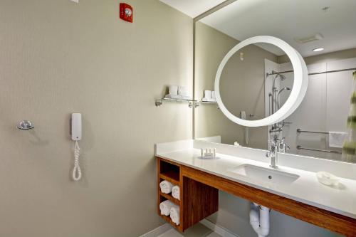 a bathroom with a sink with a mirror and a phone at SpringHill Suites Cincinnati Airport South in Florence