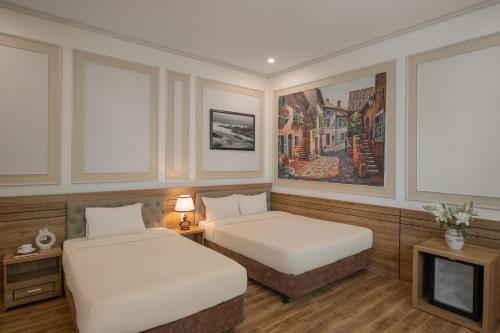a hotel room with two beds and a tv at Moon Valley Villas Đà Lạt in Xuan An
