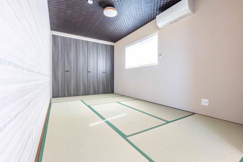 an empty room with a door and a window at Nanki Shirahama Angel in Shirahama
