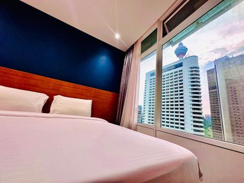um quarto com uma cama branca e uma grande janela em vortex suites klcc HOLIDAY apartment em Kuala Lumpur