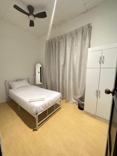 una camera con letto e ventilatore a soffitto di Te’bing Homestay a Paka