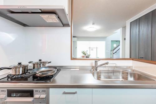 a kitchen with a sink and a stove at Nanki Shirahama Angel in Shirahama