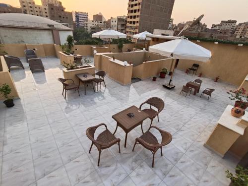 un patio con tavoli, sedie e ombrellone di Discover pyramids inn a Il Cairo