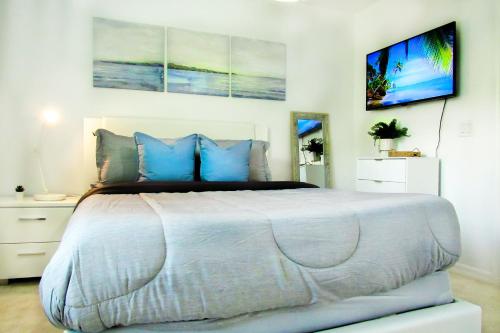 1 dormitorio con 1 cama grande con almohadas azules en Cozy 3 Bed Home Gated Great Location for Disney, en Loughman