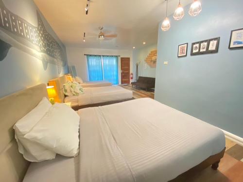 a bedroom with two beds in a room at Kalachuchi Inn 薄荷雞蛋花旅宿 in Panglao