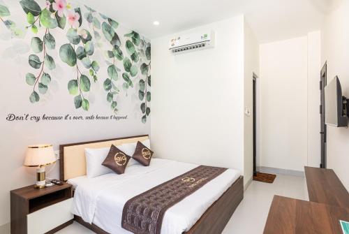 a bedroom with a bed and a wall with plants at BIG Hotel Huế in Hue
