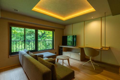 a living room with a couch and a large window at Sake Hotel Tamakiya in Tokamachi