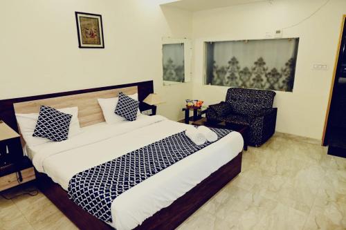 Hotel Varuna Inn في فاراناسي: غرفة نوم بسرير كبير وكرسي
