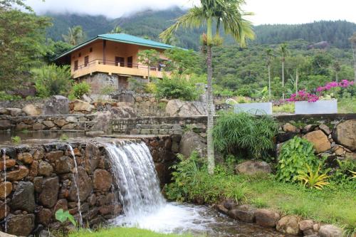 a waterfall in front of a house at World's End Base Eco-Village in Belihul Oya