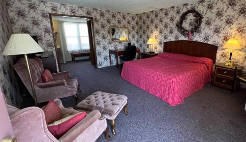 een slaapkamer met een roze bed en een stoel bij Victorian Inn in Cleveland