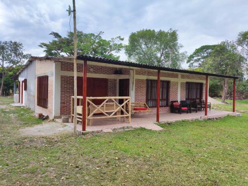 a small brick house with a porch and a yard at Hospedaje villa luz in Pitalito