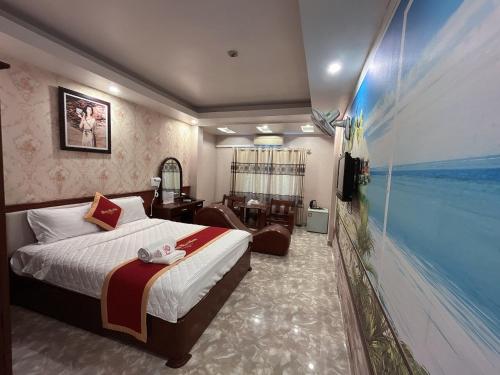 ハイフォンにあるKhách Sạn Nam Sơnのベッドと大きな窓が備わるホテルルームです。