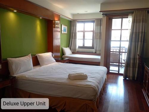 a bedroom with a large bed with a green wall at Alpine LXPD Water Chalet in Port Dickson